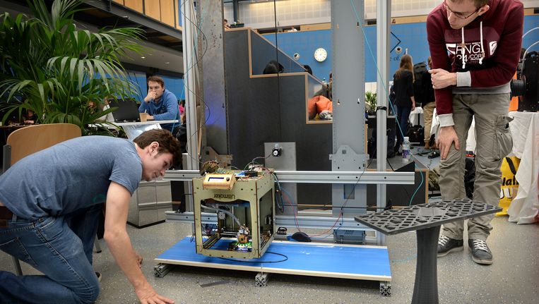 Studenten op de TU in Delft en hun ontwikkelde 3d-printer. Beeld Marcel van den Bergh /  de Volkskrant