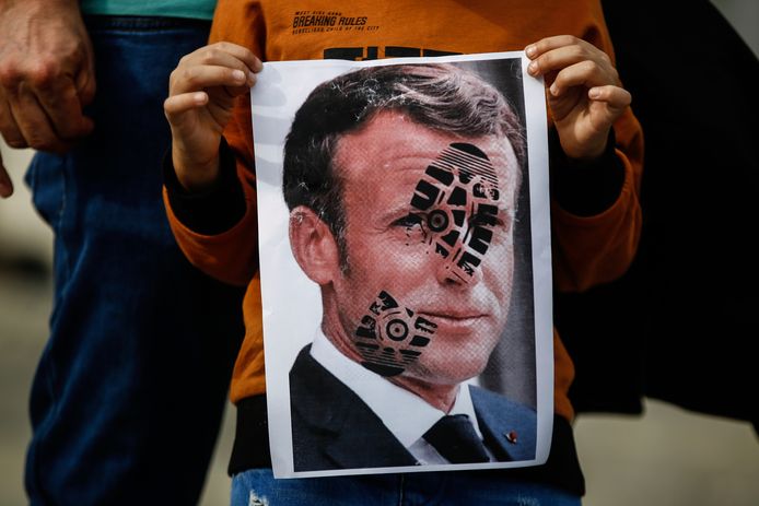Een kind in de Turkse grootstad Istanbul houdt een foto van Frans president Emmanuel Macron vast met daarop de (beledigende) afdruk van een schoen.