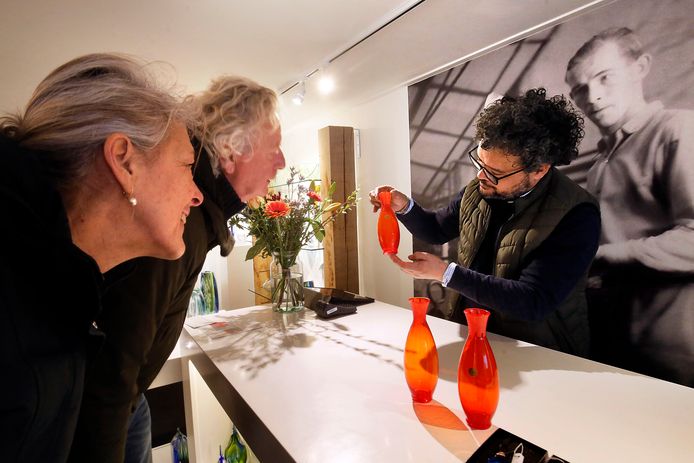 Verzamelaars Marjolein Rozeboom en Frits Decnop bewonderen het nieuwe Oranjevaasje van glasblazer Marco Lopulalan.