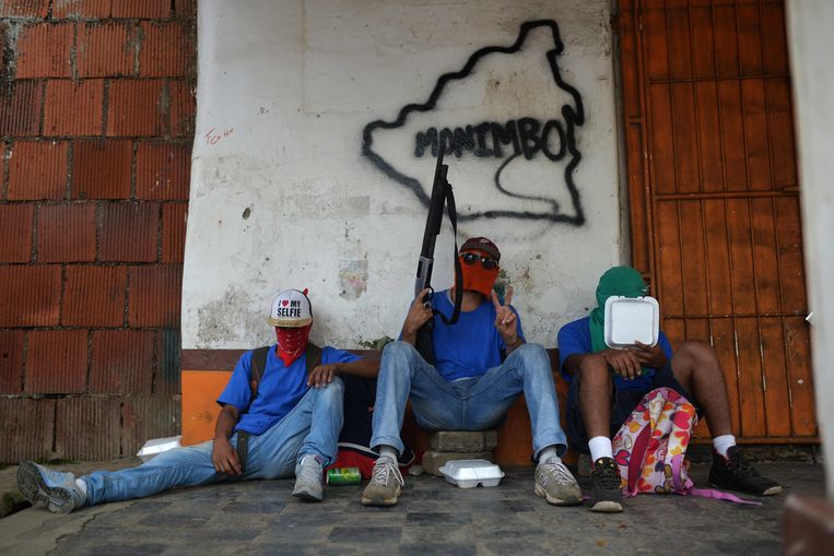 Paramilitairen rusten uit na confrontaties met demonstranten tegen Ortega. Beeld AFP