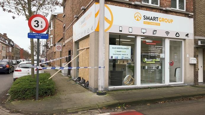 De brandweer maakte de vitrine van de telefoonwinkel dicht met houten platen.