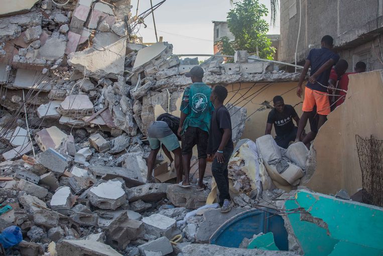 Inwoners van Les Cayes ruimen puin op. Beeld Getty Images
