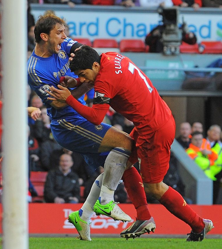 Luis Suarez bijt Branislav Ivanovic in diens arm tijdens Liverpool - Chelsea van april dit jaar. Beeld afp