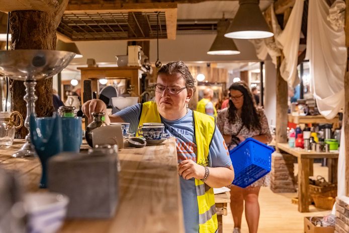 Medewerker Raymon Bult in de nieuwe kringloopwinkel in Hardenberg, met mensen van sociale werkvoorziening.