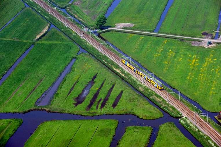 Luchtfoto van een trein die het Noord-Hollandse landschap doorkruist. Beeld Raymond Rutting / de Volkskrant