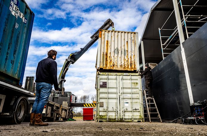 Opgestapelde zeecontainers moeten voorkomen dat de vaccinatielocatie in Dordrecht meer schade oploopt tijdens de storm Eunice.
