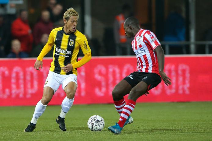 Keisuke Honda aan de bal, Lassana Faye kijkt toe.