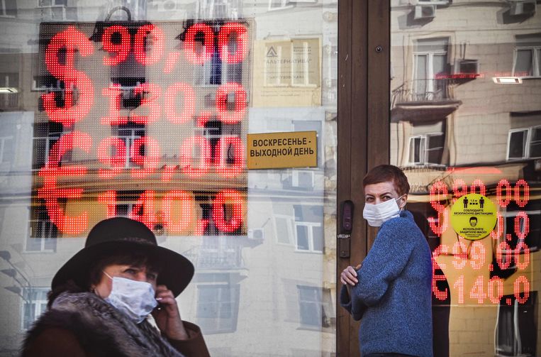 Mensen lopen maandag langs een wisselkantoor in Moskou.  Beeld Alexandr Nemenov / AFP