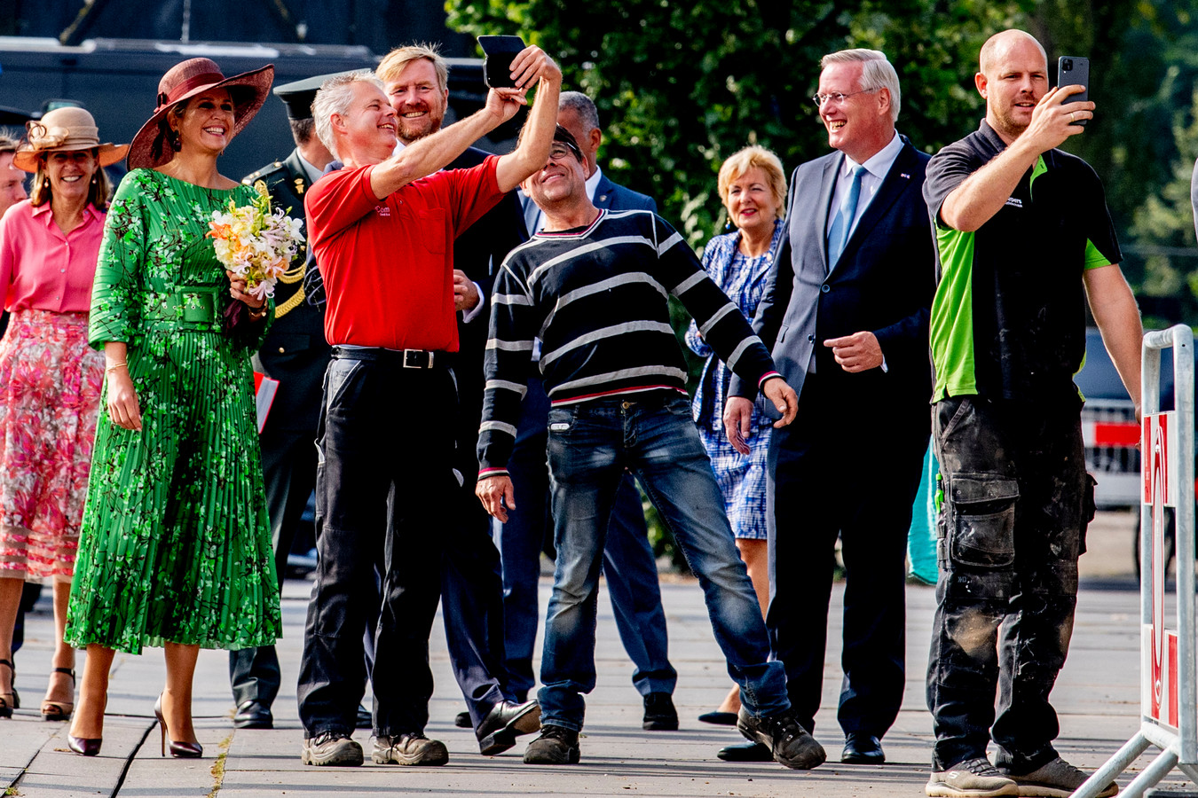 Koningin Maxima en koning Willem-Alexander bezoeken het Havenkwartier in Deventer. Bouwvakkers die aan het werk zijn grijpen hun kans voor een selfie.