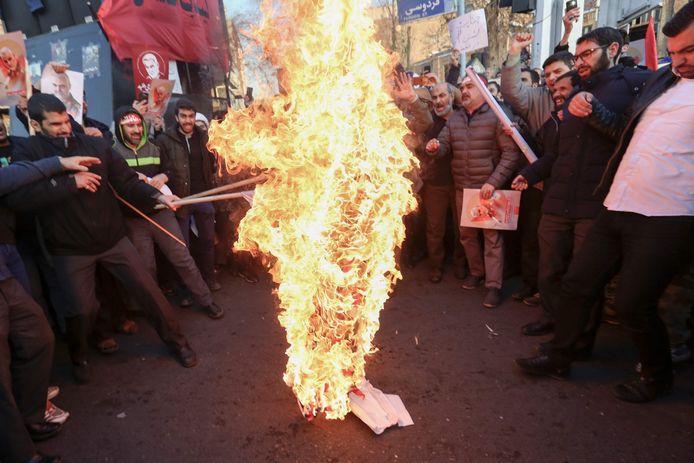 Iraanse betogers verbranden aan de Britse ambassade in Teheran een Britse en Israëlische vlag.