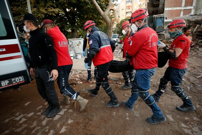 Reddingswerkers halen mensen vanonder het puin.