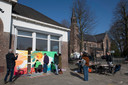 Op het plein voor de leegstaande St Aloysiusschool werken Boskampenaren aan het dorpsschilderij.