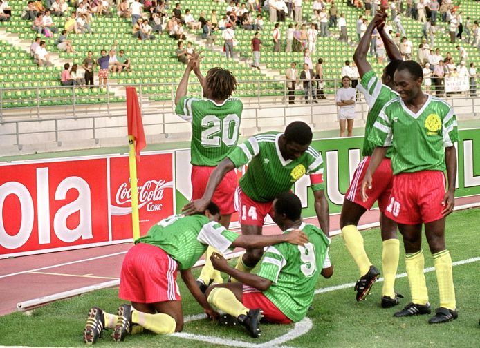 Roger Milla (9) wordt gefeliciteerd door zijn aanvoerder Stephen Tataw (14) na zijn goal tegen Roemenie op het WK 1990 in Bari, Italië.