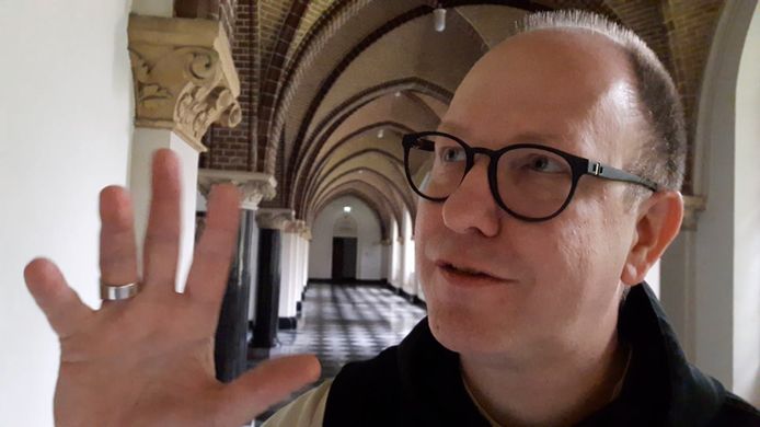 Dom Bernardus, abt van de trappisten van Koningshoeven, in de kloostergang waar de kruisweg van Albert Servaes hangt