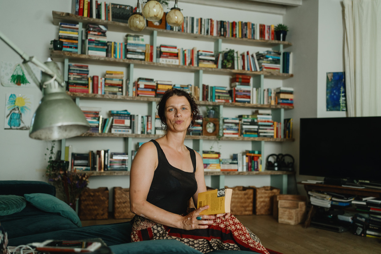 Sien Volders voor haar boekenkast: 'De boeken die mijn kinderen zouden moeten lezen, plaats ik subtiel op ooghoogte.' Beeld Wouter Van Vooren