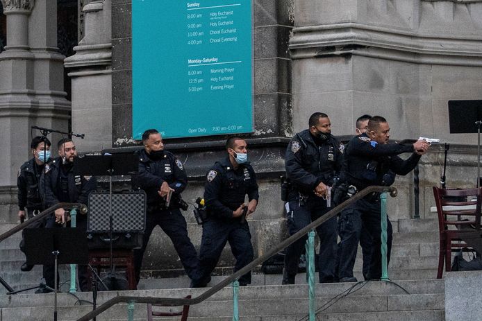 Agenten naderen de schutter op de trappen van de kathedraal.