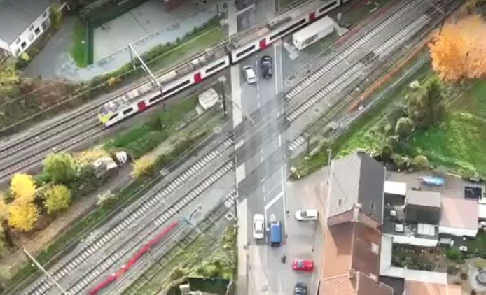 De verkeerslus is verzadigd: auto's staan tussen de sporen in file als een trein passeert.