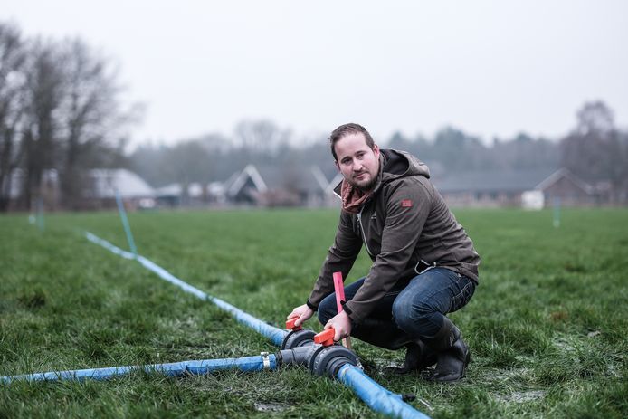Jelger Zielhorst controleert de waterslangen op het land. Uit de dikke slangen sijpelt water in de strijd tegen droogte. Foto: Jan Ruland van den Brink