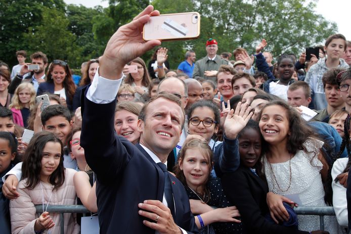 Emmanuel Macron neemt een selfie met het aanwezige publiek tijdens een ceremonie ter ere van de oproep van Generaal Charles de Gaulle tot verzet tijdens WOII.