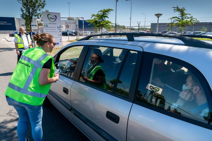 Bij de ingang van Vion in Boxtel wordt het vervoer van personeel gecontroleerd. Medewerkers kunnen er bovendien extra mondkapjes krijgen.