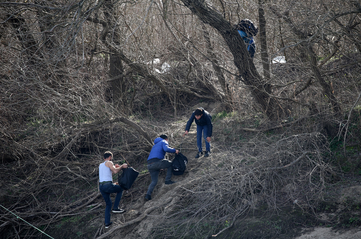 Deze jongens hebben de Griekse kant van de rivier de Evros bereikt. De kans is groot dat ze met harde hand worden teruggestuurd naar de Turkse kant. Beeld EPA