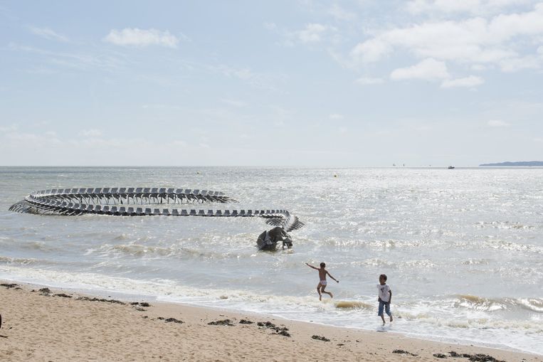 De metalen zeeslang van kunstenaar Huang Yong Ping kronkelt de oceaan uit bij de badplaats Saint-Brévin-les-Pins. Beeld Martin Argyoglo