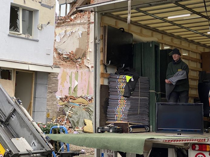 Een televisietoestel van één van de bewoners wordt in de verhuiswagen gezet