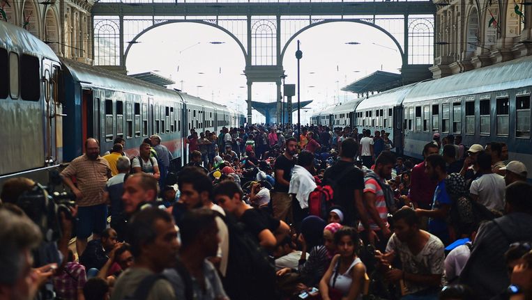 Vluchtelingen bevolken begin september 2015 het treinstation Keleti in Boedapest, hopend op een trein naar Duitsland. Beeld afp