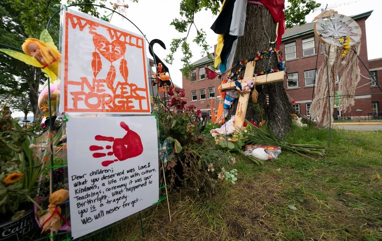 Mensen laten bloemen, boodschappen en knuffels achter bij de oude school in Kamloops. Beeld AP