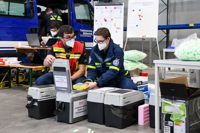 Flesjes van het BioNTech/Pfizer vaccin worden in verkoelende transportdozen verpakt.  Beeld Tobias Hase/dpa