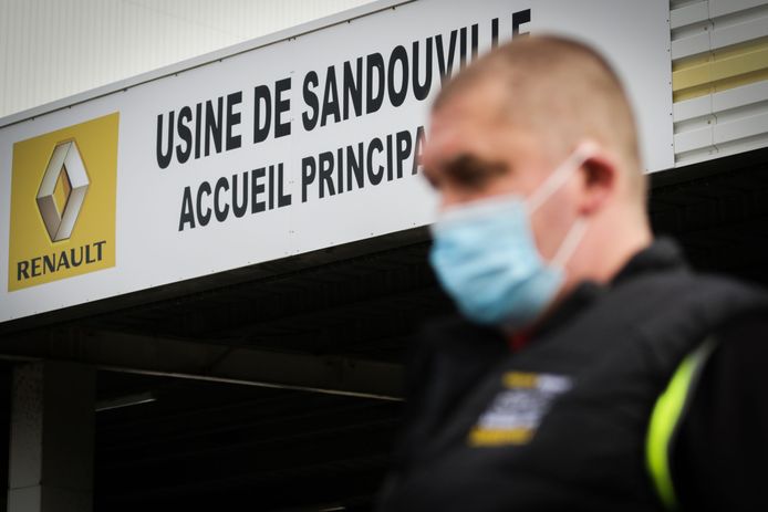 Een medewerker van Renault met mondmasker bij de ingang van de autofabriek in Sandouville, bij Le Havre. De productiehal is vandaag voor het eerst weer operationeel.