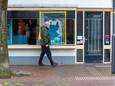 Een voorbijganger werpt een blik op de kapotte ruit van de zaak aan de Dorpsstraat.