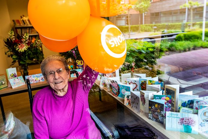 Annie Sepers - Van Os (90) achter het raam bij verzorgingstehuis Solis, omringd door een selectie van de 132 kaarten die ze kreeg. De bijzondere verjaardag gaf haar nieuwe energie. ,,Oh wat, fantastisch, fantastisch. Dit ga ik nooit meer vergeten.”