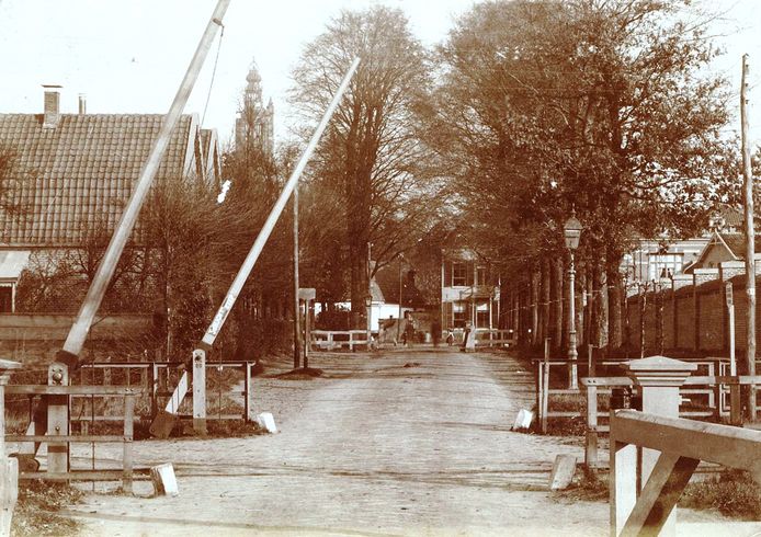 Een foto uit 1900 van de overweg ter hoogte van de toen nog onverharde Utrechtseweg. De eenvoudige spoorbomen werden destijds bij het naderen van de trein handmatig bediend.