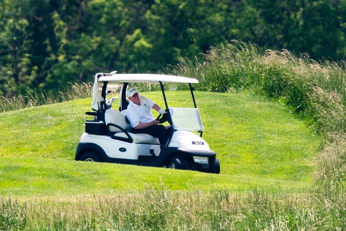 Amerikaans president Donald Trump in een golfwagentje in zijn Trump National Golf Club, een van zijn zeventien golfresorts wereldwijd (twaalf in de VS, twee in Schotland, twee in Dubai en één in Ierland).