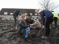 Gwenn Geerings (links) en Madelief van Heel planten hun bomen in het 'tiny forest' op het IJsselplein in Helmond.
