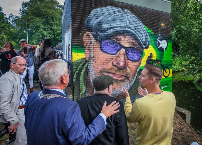 René Bom is erg vereerd met zijn muurschildering aan de Vreeswijkstraat. Hier kijkt hij bewonderend naar de onthulling met burgemeester Jan van Zanen en kunstenaar Roelof Schierbeek (rechts).