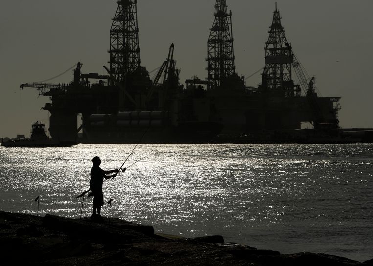 Een visser bij een olieplatform in Port Aransas, Texas.  Beeld AP