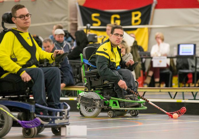 Matthijs Mol in actie (groene rolstoel en geel jack) aan de bal.