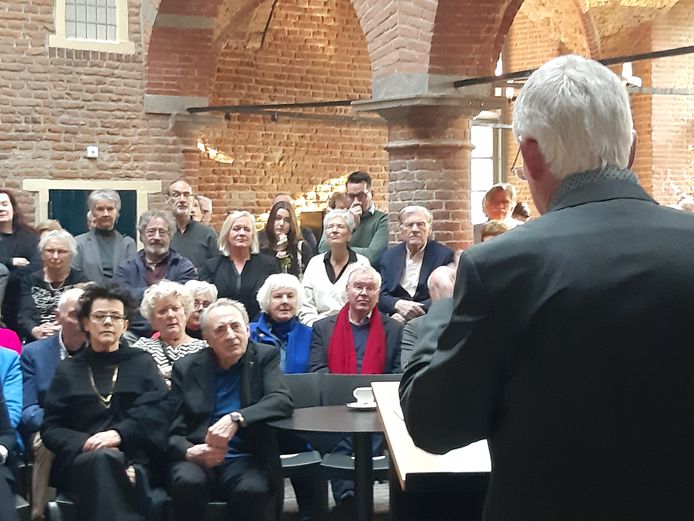 Harrie Gerritz (zittend met de arm op tafel) wordt toegesproken door Frank van de Schoor, voormalig conservator van museum Het Valkhof in Nijmegen.