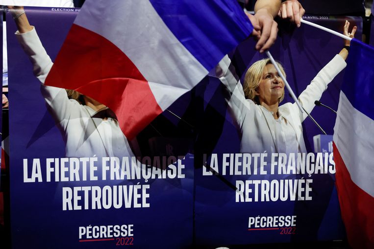 Aanhangers van presidentskandidaat Valérie Pécresse zwaaien met vlaggen tijdens de campagnebijeenkomst in de Zénith-concerthal in Parijs. Beeld REUTERS