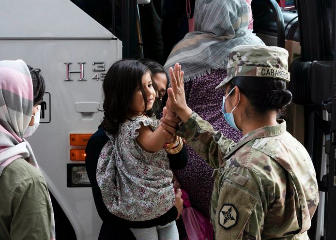 Een Amerikaanse soldaat geeft een high-five aan een Afghaans meisje uit Kaboel na geland te zijn op Dulles International Airport in Virginia.