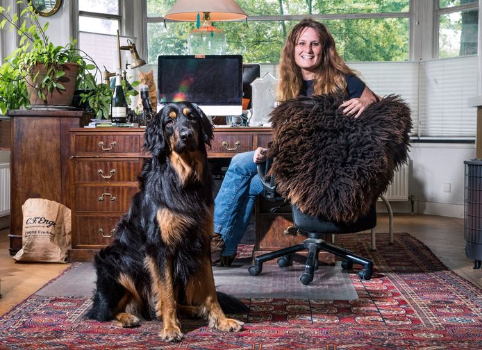 Nicolette van der Werff in haar werkkamer met haar hond Homer Jackson en links van de monitor kat Mitzy.