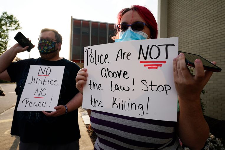Burgers protesteren tegen de dodelijke schietpartijen door politieagenten: 'de politie staat niet boven de wet', staat er te lezen op het rechtse bordje. 'Stop het moorden!' Beeld AP
