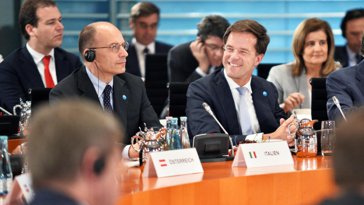 Premier Rutte tijdens de top in Berlijn. Achter hem minister Asscher (Sociale Zaken). Beeld getty