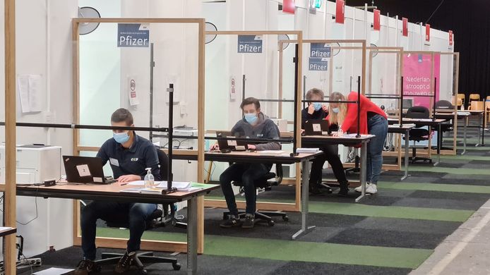 Tijdelijke krachten zitten bij de GGD in Wijchen achter hun laptops klaar voor de mensen die zich willen laten vaccineren.