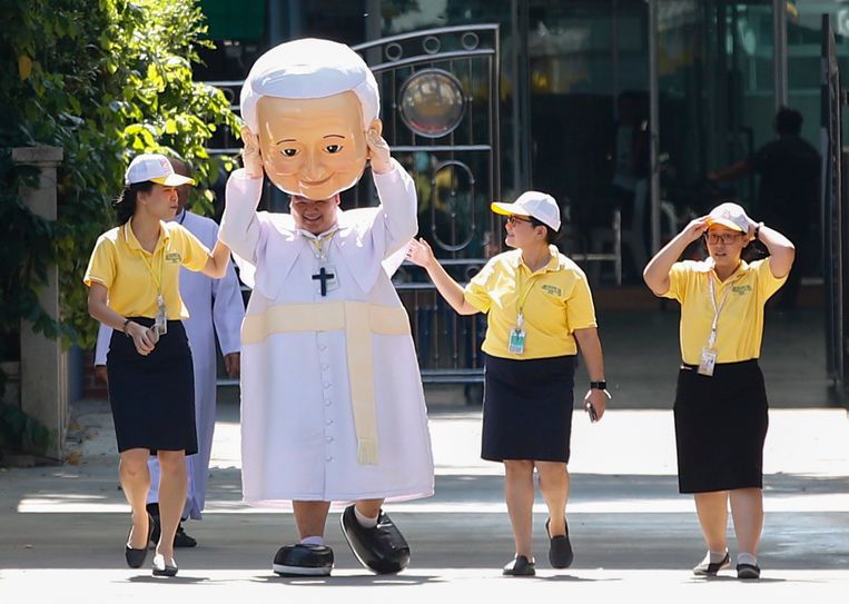Een Thaise man wandelt in een Franciscus-pak bij de St. Louis-kerk in Bangkok. De kerk ligt naast de nuntiatuur waar de paus gisteren zijn driedaagse bezoek aan Thailand begon. Dat valt samen met de viering van 350 jaar ‘Mission de Siam’. Franciscus is de eerste paus in ruim veertig jaar die het land bezoekt. Beeld EPA