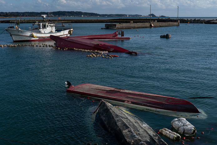 Omgedraaide vissersboten bij een haven in Suzu na de passage van tsunami’s door de beving.