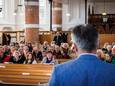 Dominee Cor Harryvan spreekt de kerkgangers in Steenwijk toe in het Oekraïens.