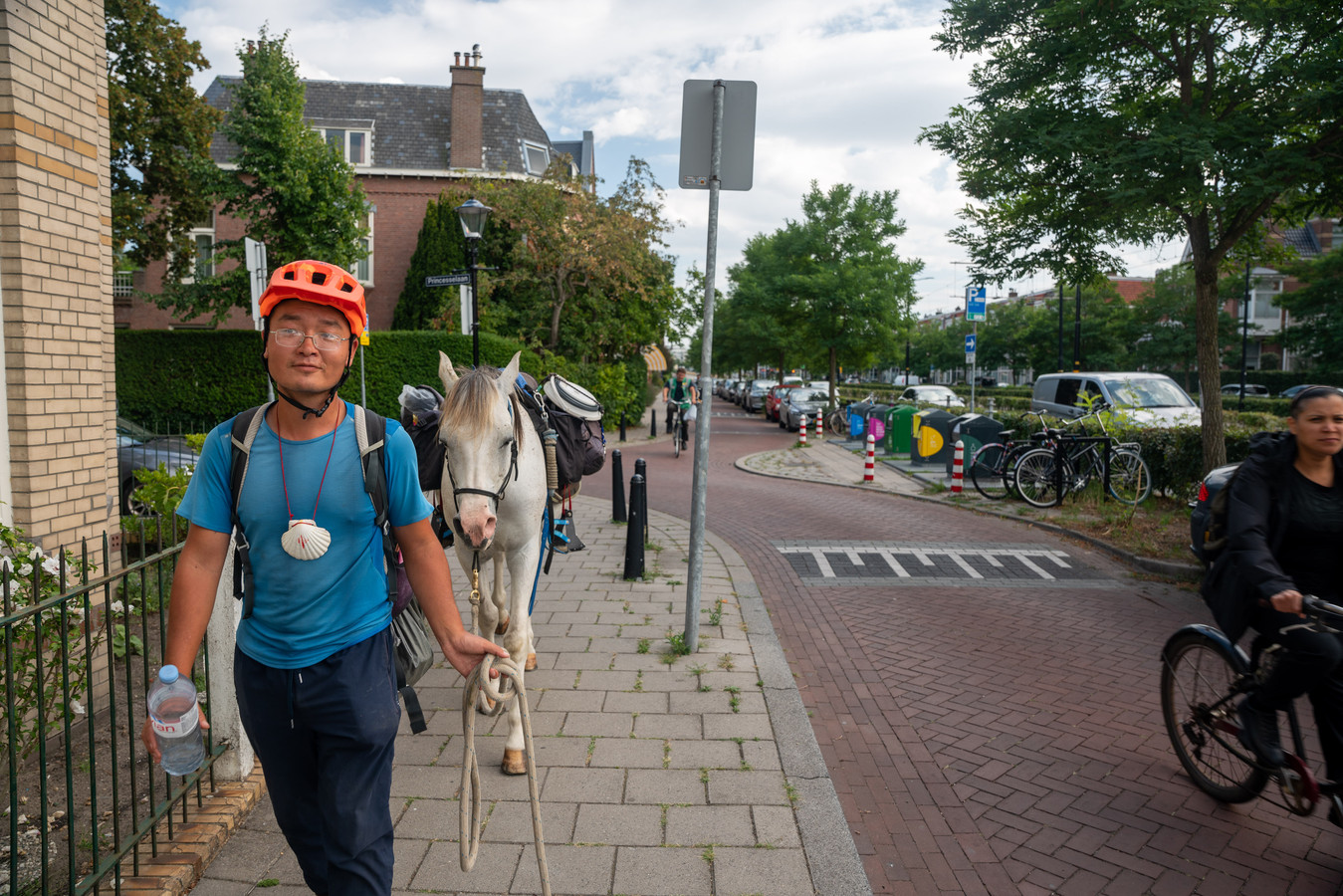 Xu Zhixian met zijn paard langs de Haagweg in Rijswijk. Het duo heeft samen al 2500 kilometer afgelegd.